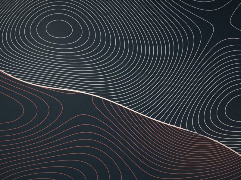 Topographic contour lines in cream and terracotta meeting along a diagonal seam on dark slate